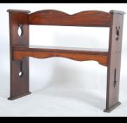 A 1940's oak hall settle bench having a planked seat with pierced supports and shaped top rail.