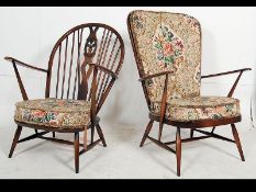 A pair of Ercol beech and elm wood Windsor pattern armchairs raised on turned legs with stretchers