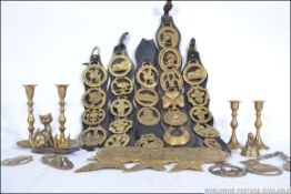 A good collection of vintage 20th century horse brasses most still attached to leather martingales.