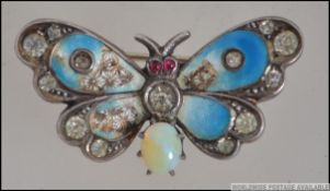 A silver, guilloche enamel set and moonstone Art Nouveau butterfly brooch,