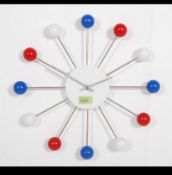 A vintage style atomic wall clock having a white face with a quartz movement red,