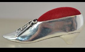 A silver pin cushion in the form of a Georgian gentlemans show having red velour cushion,