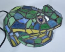 A contemporary Tiffany style table lamp in the form of a frog being wired.