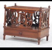 A Victorian mahogany fret worked Canterbury magazine stand being raised on turned legs with lattice
