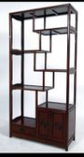 A Chinese rosewood room divider bookcase having sectional shelves raised on shaped legs with