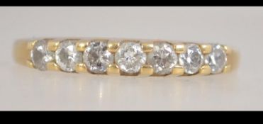 A hallmarked 18ct gold and diamond ring set with 7 round cut diamonds in a prong setting.