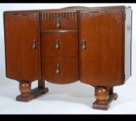 A good 1930's Art Deco oak sideboard having shaped form with drop centre top over a series of