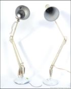 A mid century Herbert Terry anglepoise desk lamp raised on circular base together with another