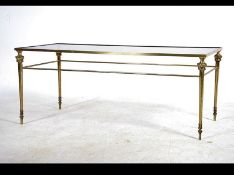 A mid 20th century coffee table having a rectangular drop in glass top raised on a lacquered brass