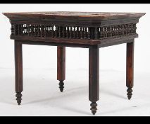 An early 20th century anglo-colonial Chinese hardwood table being raised on squared legs with