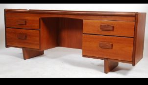 A 1970's low sideboard desk unit of Danish origin having raised pedestals of drawers with recessed