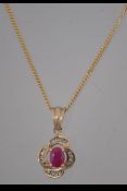 A hallmarked 9ct gold pendant necklace strung with a ruby and diamond set pendant.