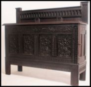 An 18th / 19th century carved oak Jacobean sideboard coffer being raised on stile legs with carved