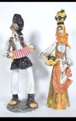 A pair of 20th century large Italian figurines to include a man with accordion and a woman with