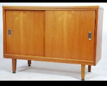 A retro 20th century teak sideboard having twin doors opening to reveal shelved interior raised