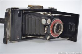 A vintage early 20th century Coronet bellows camera complete with the leather carry case