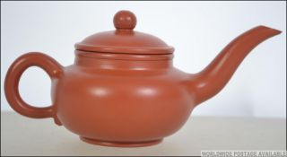 A Chinese terracotta yi-xing teapot complete with the lid having incised markings to the base.