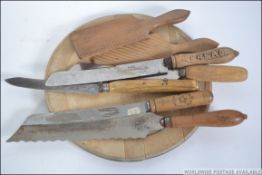A selection of vintage kitchenalia to include breadboard with carved details and wooden handled