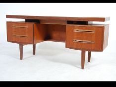 A G-Plan Kelso desk with suspension set top being raised over pedestals either side of open