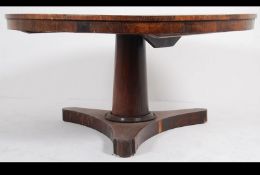 A 19th century Regency rosewood upholstered tilt top breakfast / loo table raised on turned column