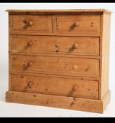 An antique style pine chest of drawers raised on plinth base with short over deep configuration and