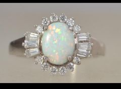 A ladies contemporary silver and opal and cz adorned ring. The cabochon opal with cz surrounds.