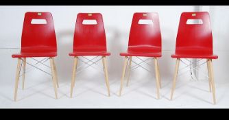 A collection of 4 Eames style DSW dining chairs. The dining chairs having red seat pads.