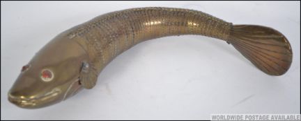 An unususal large brass articulated fish with glass eyes. The articulated body with swivel action.