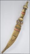 A brass and copper handles dagger probably of Middle Eastern origin having a curved steel blade