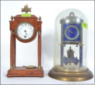 An early 20th century glass dome brass and enamel set anniversary clock raised on brass base