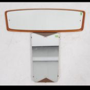 A 1970's teak wood atomic style frameless wall mirror set to a shaped teak back plate together with