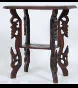 An early 20th century Chinese carved hardwood occasional table raised on griffin leg supports with