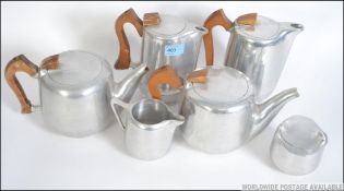 A 1950's 4 piece Piquet Ware stainless polished steel and wooden service together with 2 similar