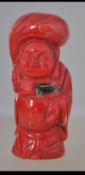 A Chinese coral figure of an elder - buddha having concentric circular type seal marks to the base