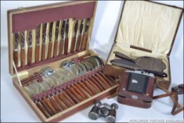 A vintage 1950's canteen of cutlery together with a pair of opera glasses,