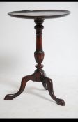 A late 19th century tripod wine table being raised on splayed legs with paw feet and terraced top