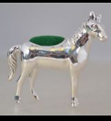 A sterling silver pin cushion in the form of a horse having green velour pin cushion. Weight 18.