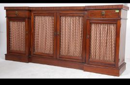 An Edwardian mahogany breakfront pier cabinet sideboard having plinth base with curtain lined doors