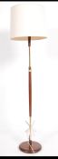 A retro 20th century teak and brass ring column standard lamp supported on a circular base with