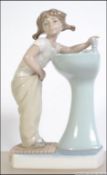 A Lladro ceramic figurine entitled ' Clean up time '. The figurine of girl at sink in towel.