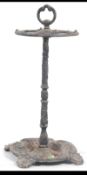 A Cast iron early 20th century stick stand having circular base and central tall handle with loop