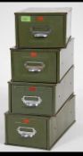 A stack of four vintage industrial factory metal index filing drawers finished in military green