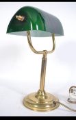 A 20th century bankers desk / work lamp having brass base and upright support below the green glass