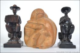 A pair of mid 20th century wooden carved bookends of a man playing an accordion and a man drinking