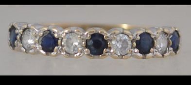 A hallmarked 9ct gold half eternity ring set with sapphire and white stones. Hallmarked for London.