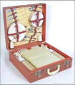 A vintage 20th century retro Brexton picnic case in red being fully fitted with flasks,