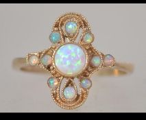 A hallmarked 9ct gold and opal ring in the gothic style set with opal cabochons with granulated