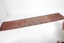 A 20th century Iranian - Persian hand woven runner rug with central large run of medallions with