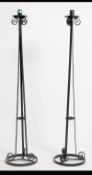 A pair of 20th century tall wrought ebonised metal candle stands.