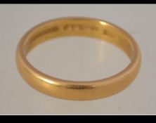 A hallmarked 22ct gold wide band ring. Hallmarked London. Size Q. Weight 4.